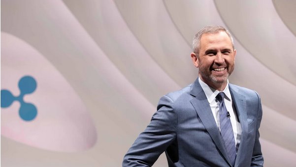 Brad Garlinghouse, PDG de Ripple, sur scène devant le logo Ripple