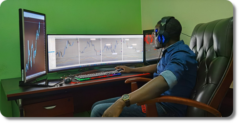 Trader africain devant plusieurs écrans de trading forex